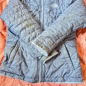 The North Face Blue Puffer Jacket with Quilted Texture and Zip-Up Style